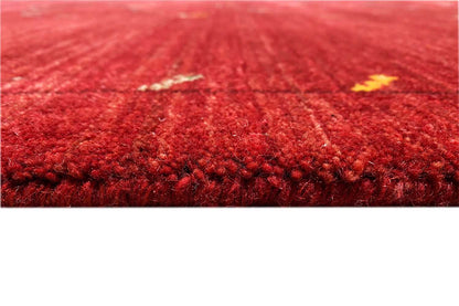 Close-up: red Gabbeh rug with dense pile and small touches of color