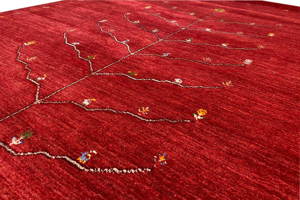 Close-up: red Gabbeh rug with a branching tree-and-vine pattern