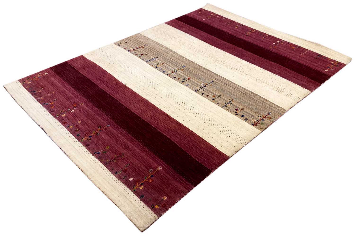 Gabbeh rug at an angle: burgundy fields, cream-colored bands, decorative patterns in the central stripe