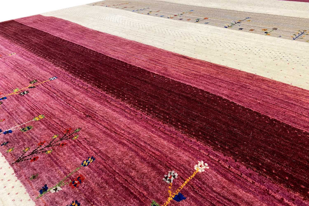 Gabbeh rug detail: burgundy weave, cream-colored border and colorful patterns