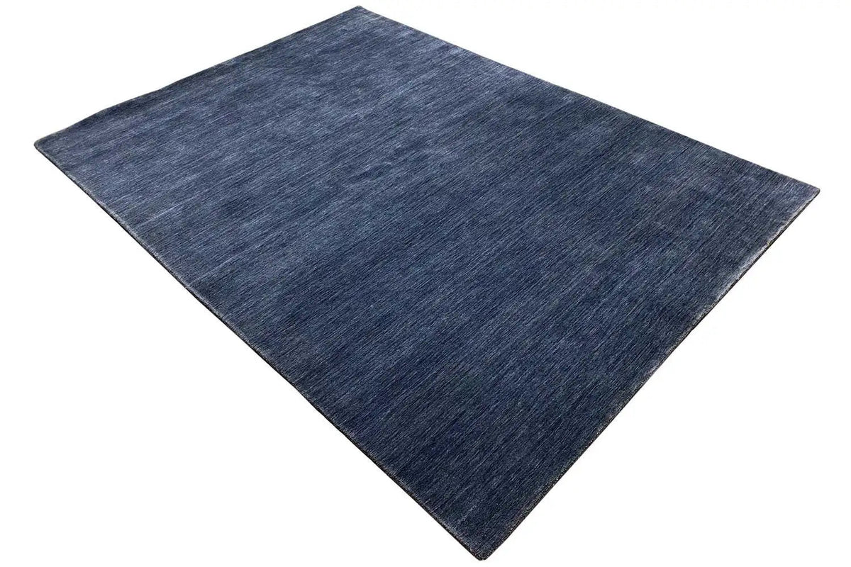 Blue rectangular Gabbeh rug, spread diagonally, with an even pile.