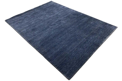 Blue rectangular Gabbeh rug, spread diagonally, with an even pile.