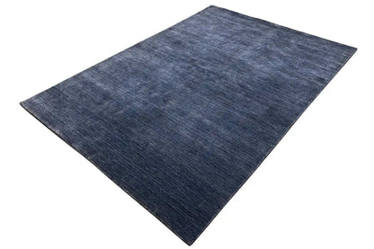 Blue rectangular Gabbeh rug, slightly angled, with a short pile.