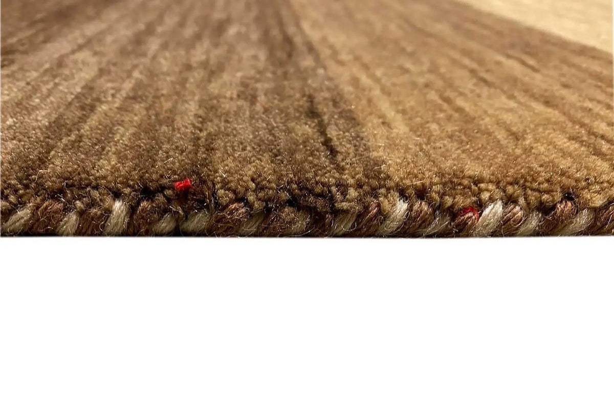 Close-up of the pile: brown-beige Gabbeh rug with a dense wool texture