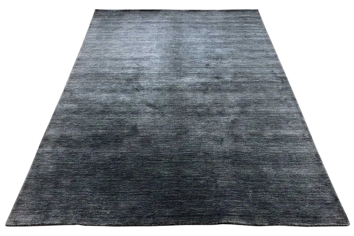Large rug with a dark blue-gray, heathered design and short, dense pile