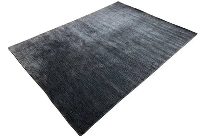 Rug in dark blue-gray with a heathered pattern, spread out diagonally