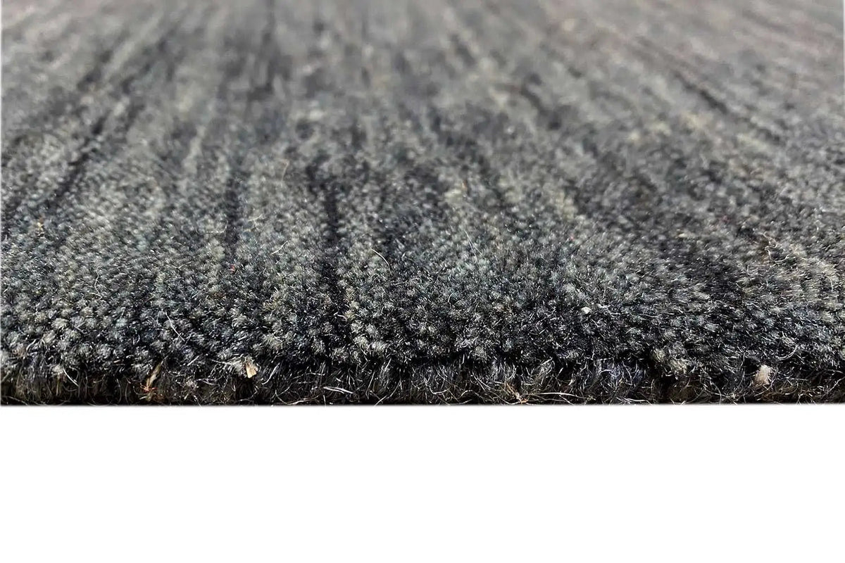 Close-up: mottled dark blue-gray pile with a dense woven texture at the edge