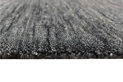 Close-up: mottled dark blue-gray pile with a dense woven texture at the edge
