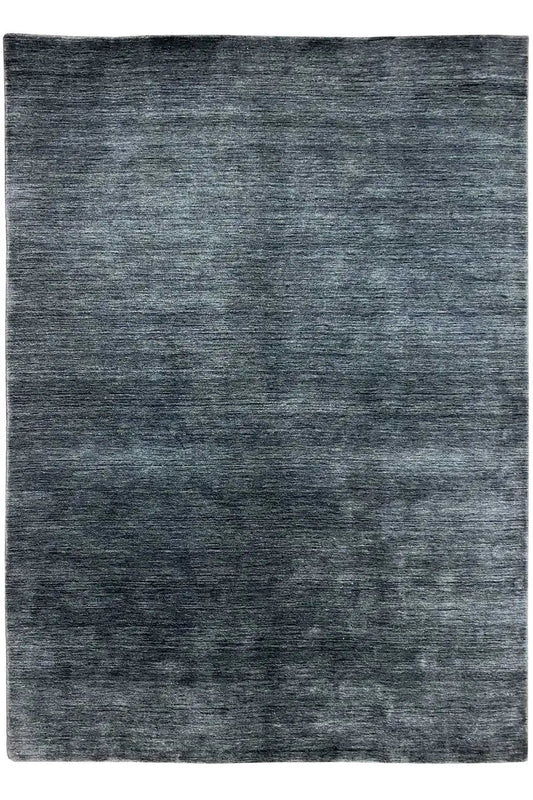Rectangular rug in dark blue-gray with a mottled, irregular surface pattern