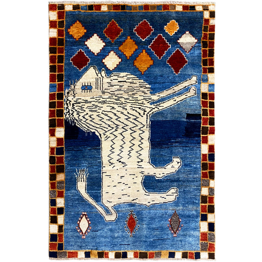 Blue Gabbeh rug with a white lion motif, colorful diamonds, and a checkered border.