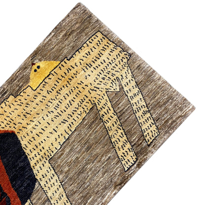 Gabbeh rug detail: yellow ornamental band and lion’s head in dark blue