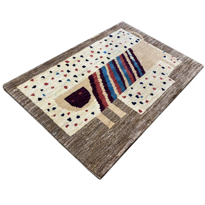 Gabbeh rug in an angled view, cream-colored with a striped pattern and dark corner motifs