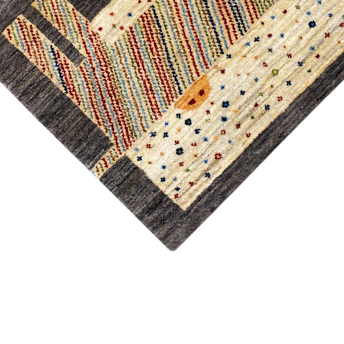 Gabbeh rug corner detail: cream-colored area with colorful dots and stripes