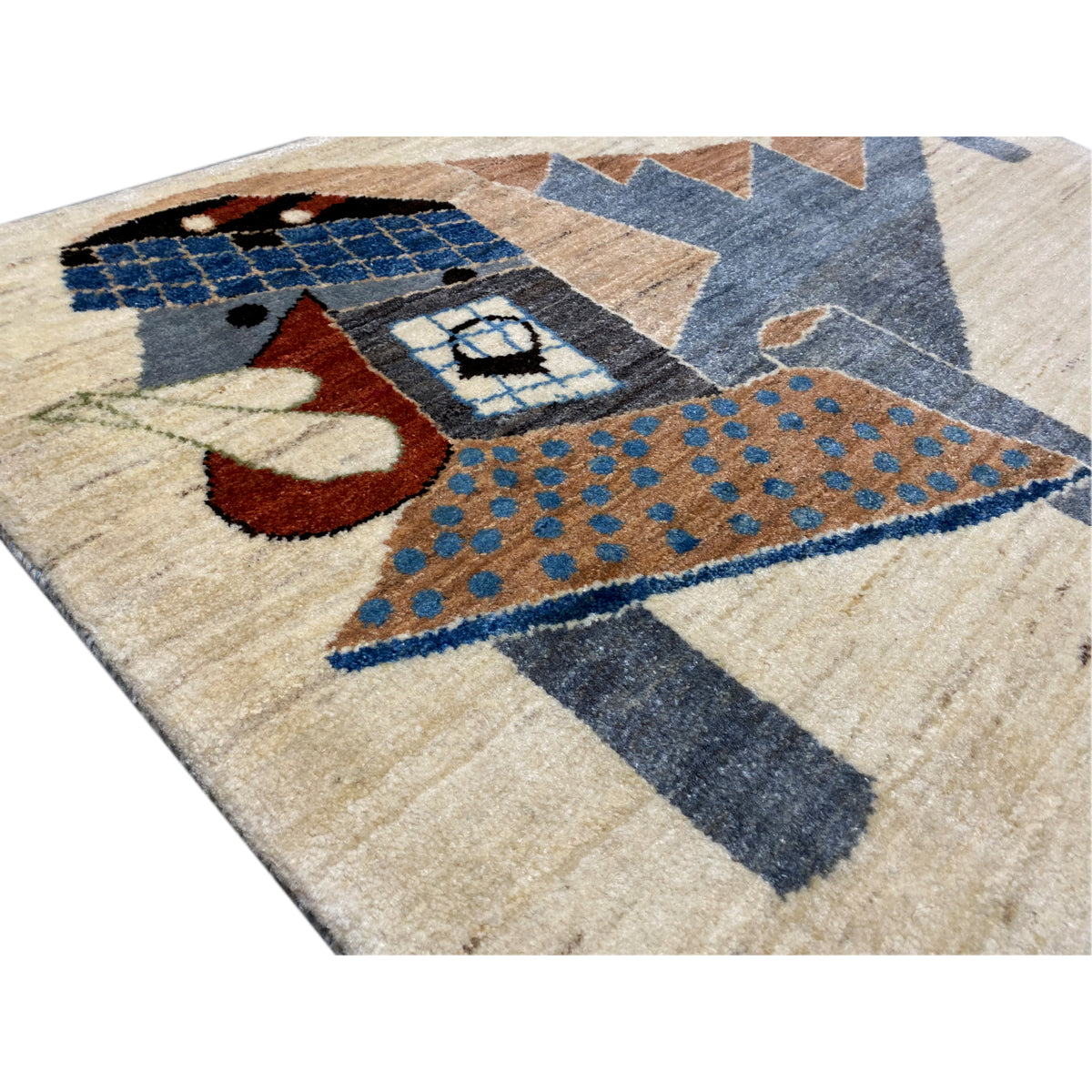 Gabbeh rug detail view: blue square, beige pile, brown and red accents