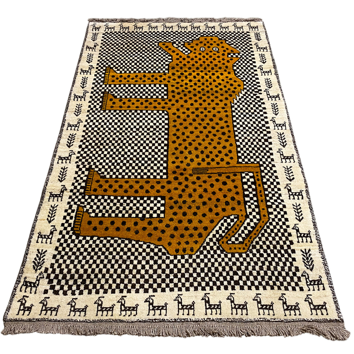 Rectangular Gabbeh rug with a yellow leopard figure on a black-and-white pattern, fringes