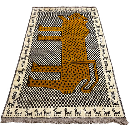 Rectangular Gabbeh rug with a yellow leopard figure on a black-and-white pattern, fringes