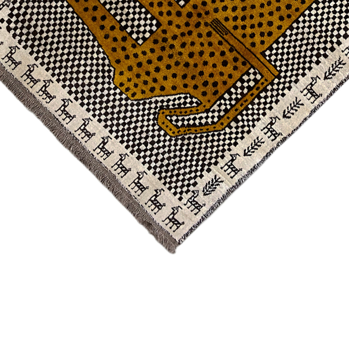 Corner view of the Gabbeh rug with a leopard motif, dotted pattern, and decorative border