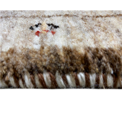 Close-up of carpet pile: beige and brown fibers with small colorful embroidery