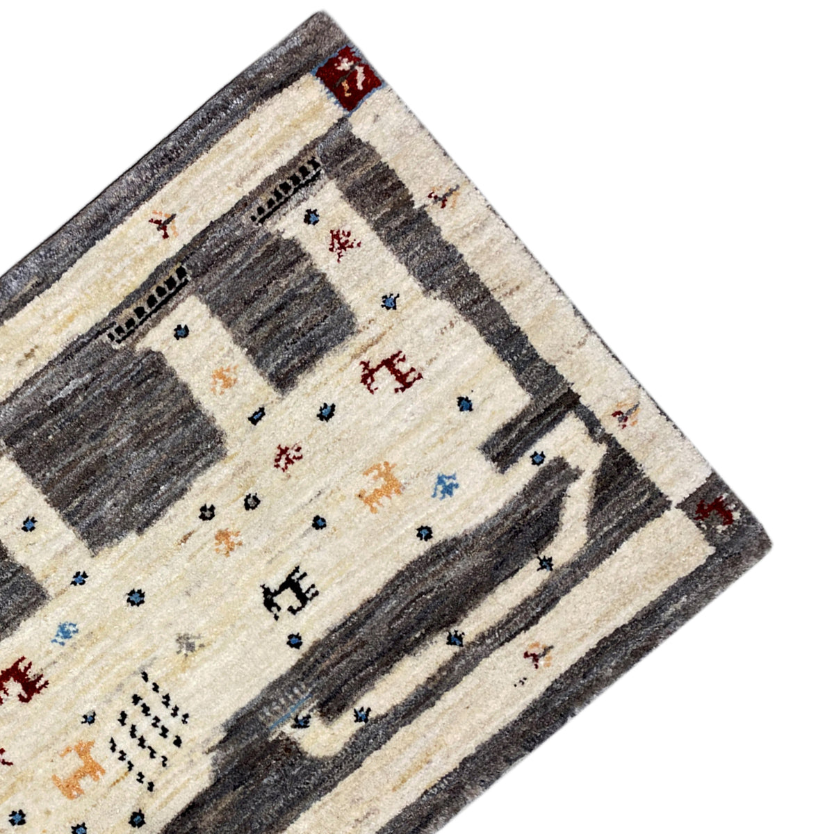 Corner of the Gabbeh rug: cream and dark gray with red accents along the edge