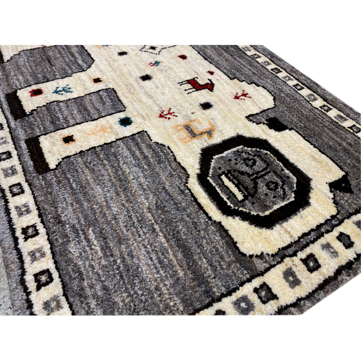 Close-up of a Gabbeh rug: gray fields, an ecru area, and decorative details