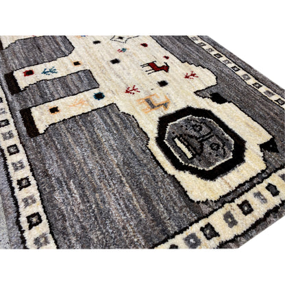 Close-up of a Gabbeh rug: gray fields, an ecru area, and decorative details