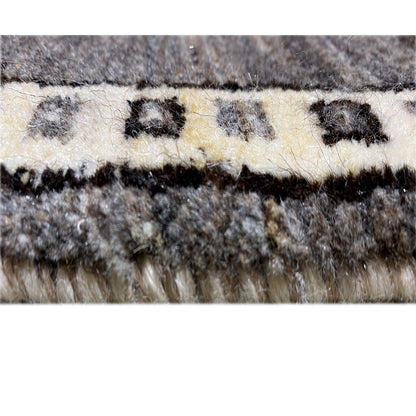 Rug edge with dense fringes in gray and ecru