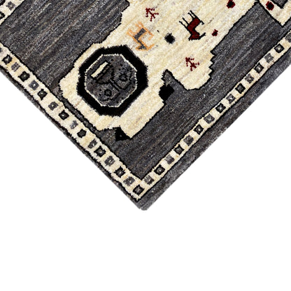 Close-up of the corner: gray-ecru Gabbeh rug with a dark inner border
