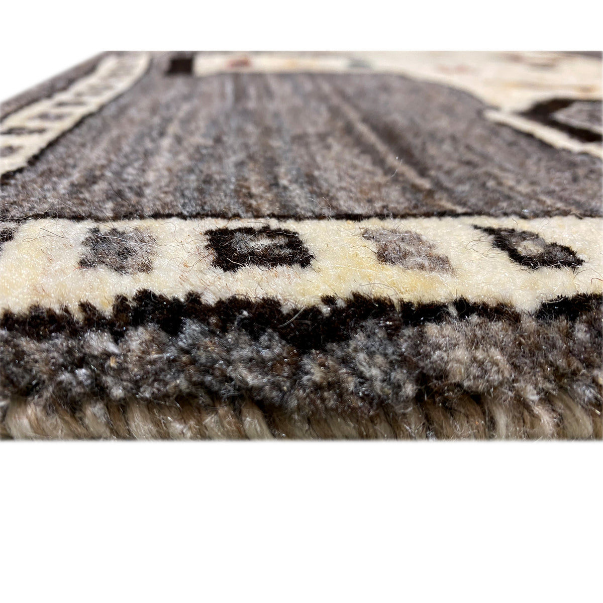 Carpet pile in detail: gray and cream-colored yarn with a dense, short structure