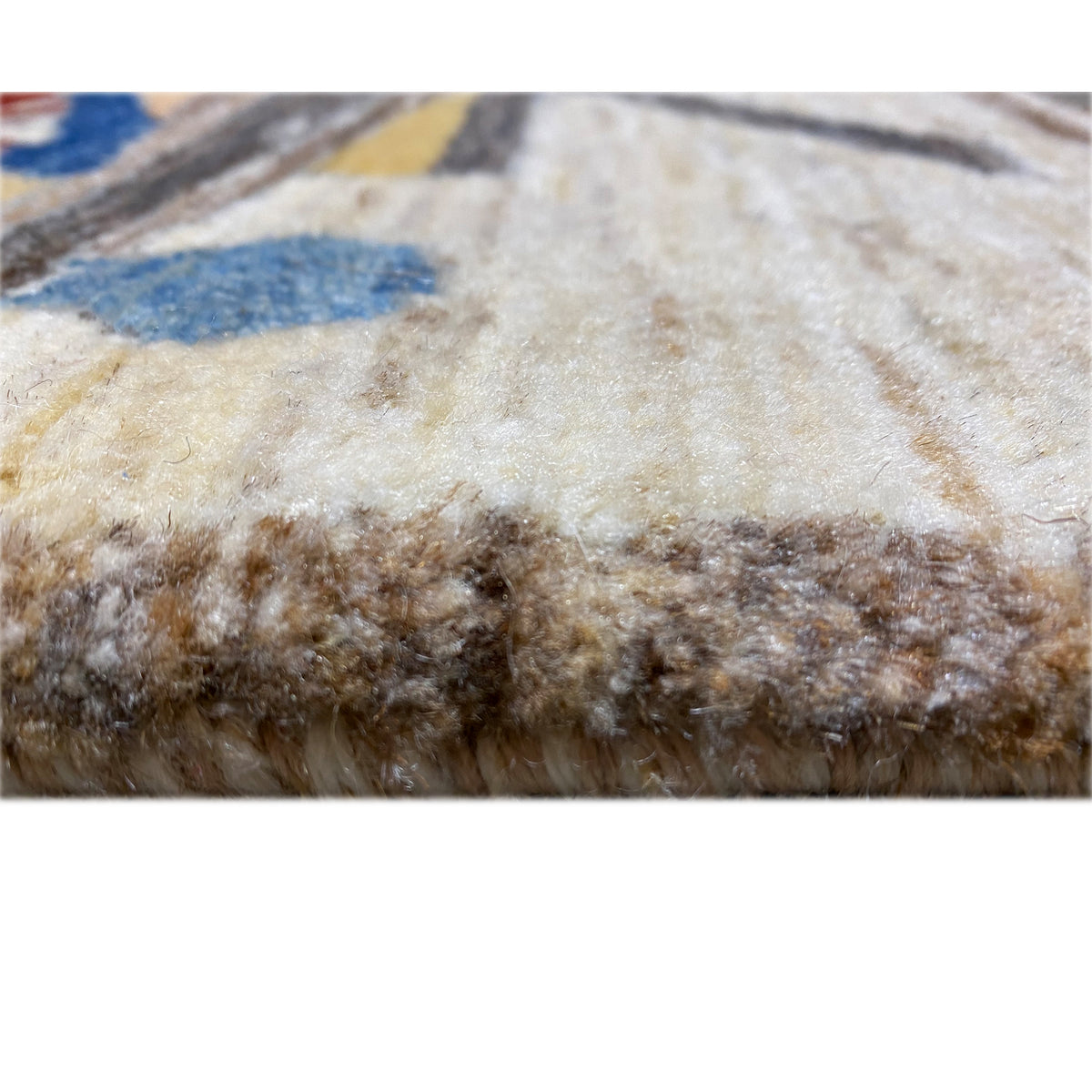 Close-up of the back of a rug: dense pile with brown fibers and a beige base surface