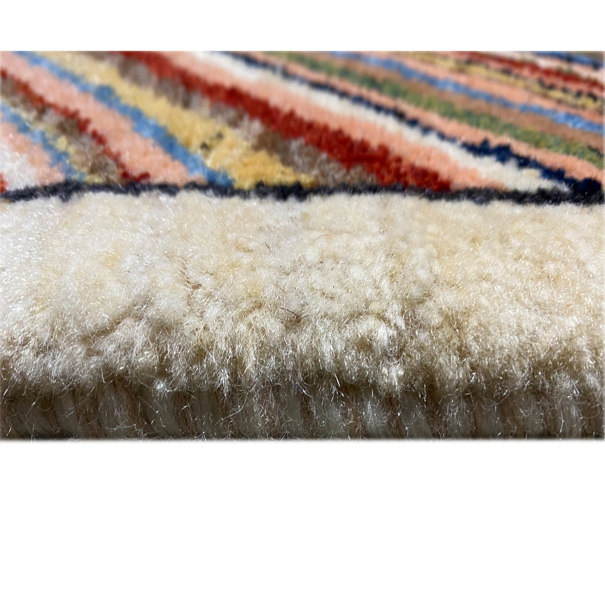 Beige carpet, pile and border in close-up with multicolored edge