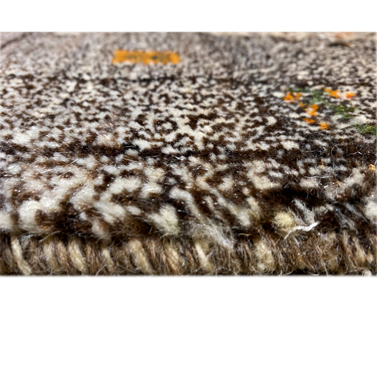 Floral detail of the Gabbeh rug with beige sections and orange accents
