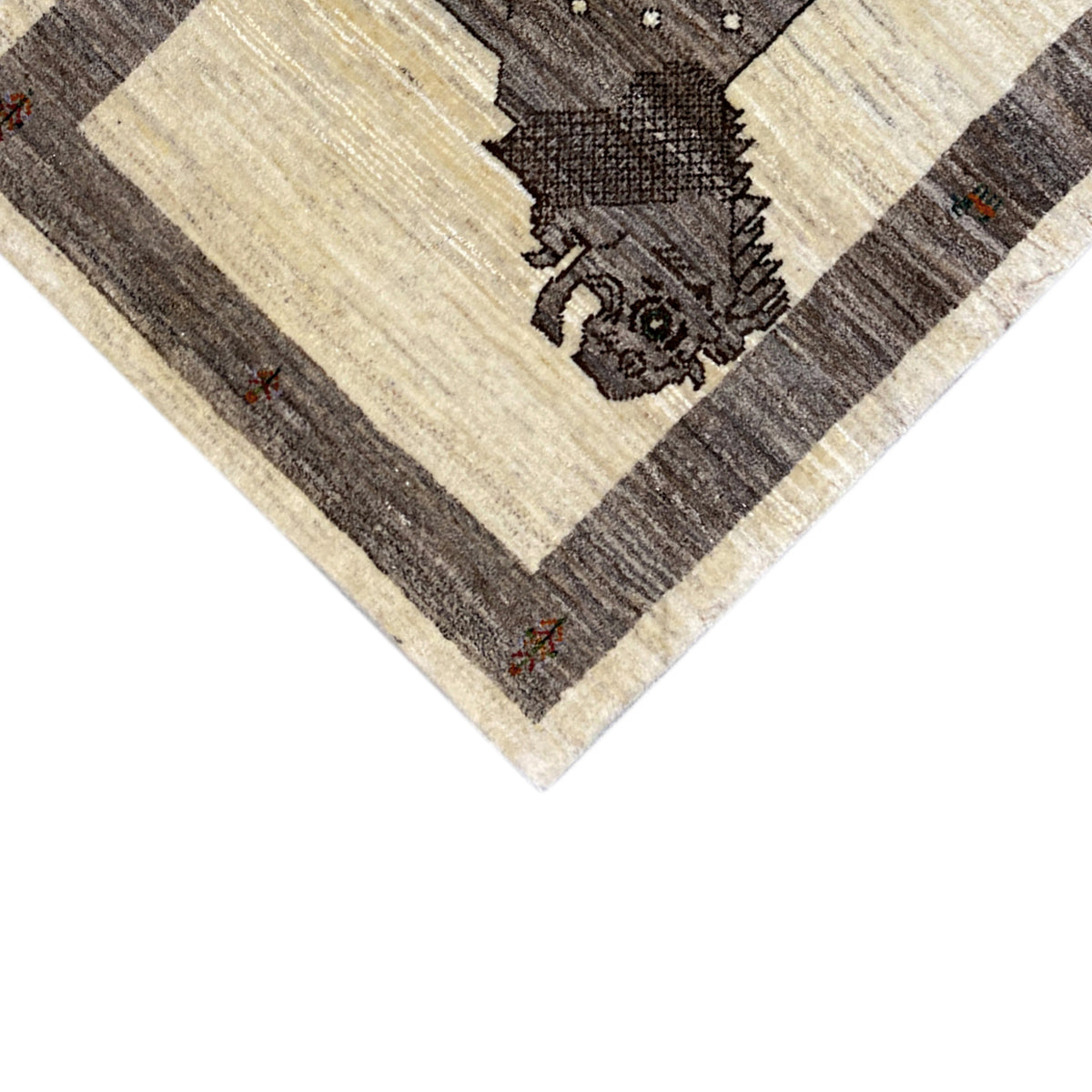 Detail of the lion motif on a beige Gabbeh rug, framed by dark stripes.