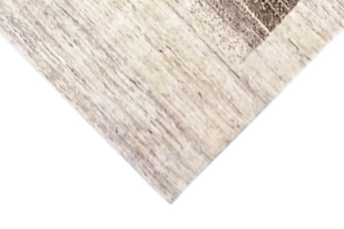 Corner of the oriental rug: cream-colored pile with a brown gradient and straight-edge finishing