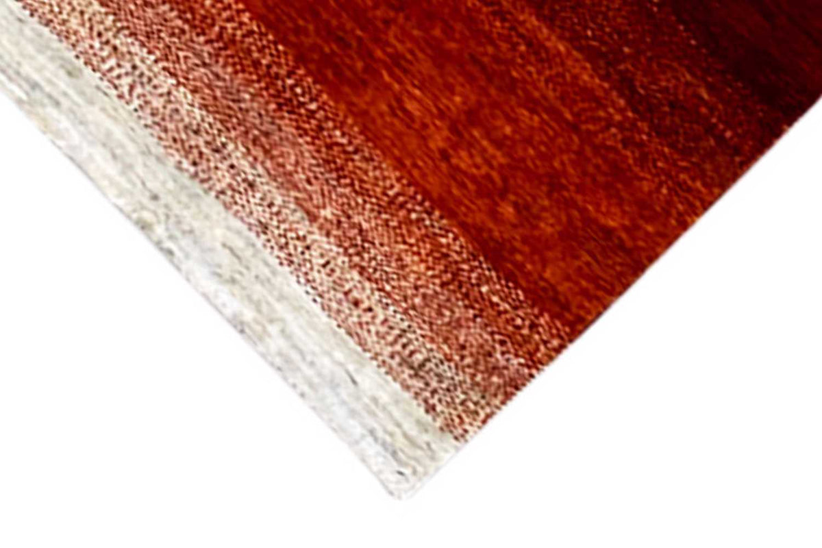 Carpet edge with a cream-colored border and orange-red stripe pattern