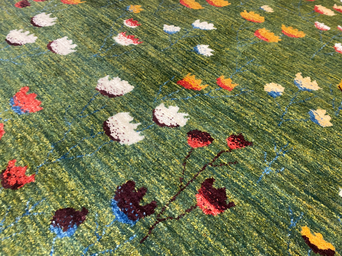Detailansicht: bunte Blumenmotive auf olivgrünem Teppich mit Linienoptik