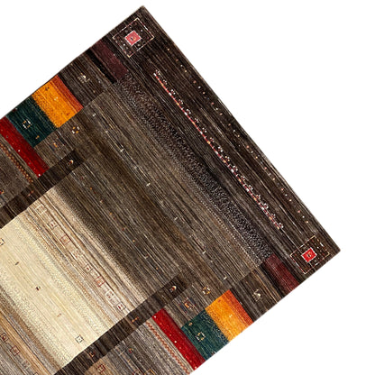 Gabbeh Luri rug viewed from above at an angle: brown pattern with beige areas and colorful stripes