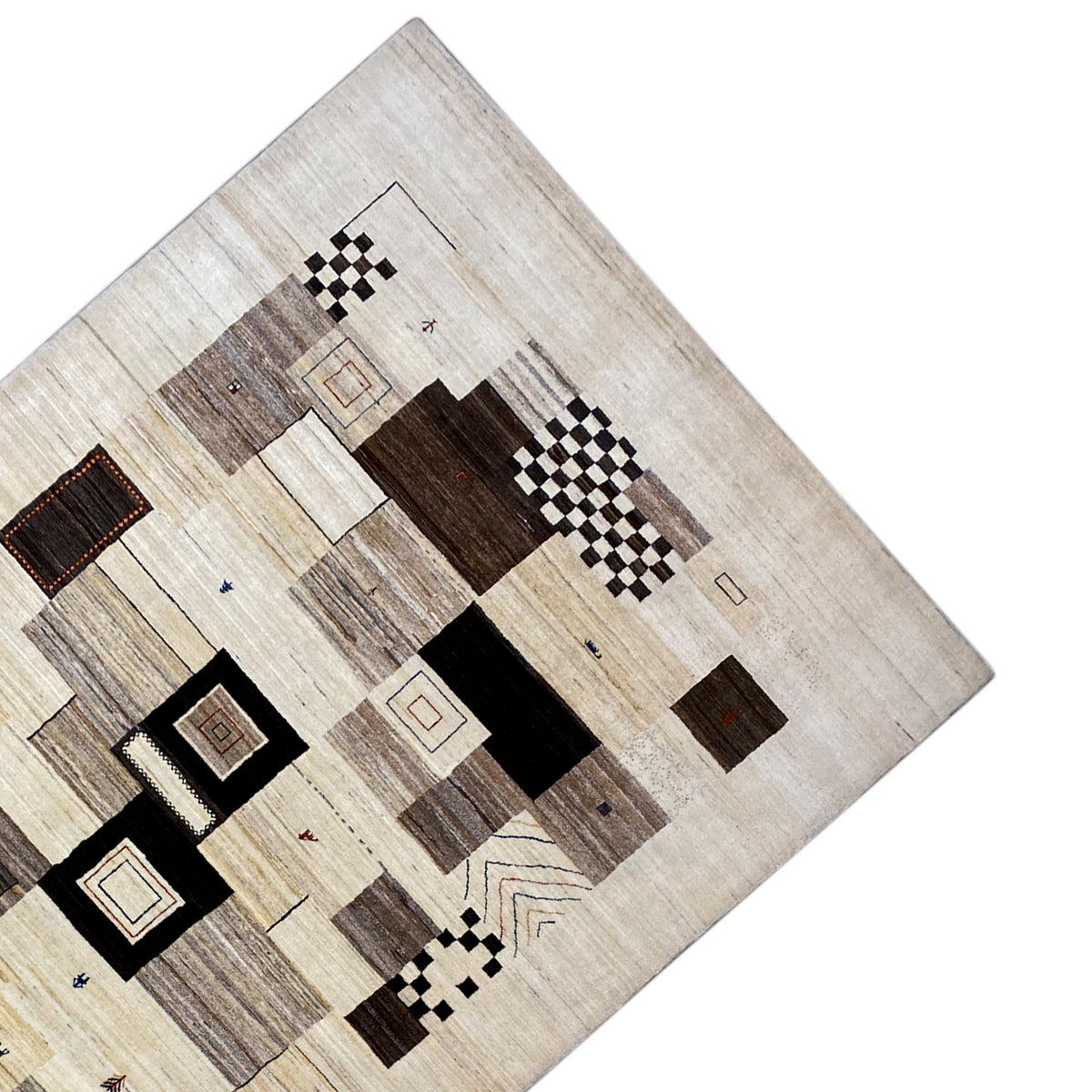 Rug detail: beige patchwork with black squares, brown sections, and small lines