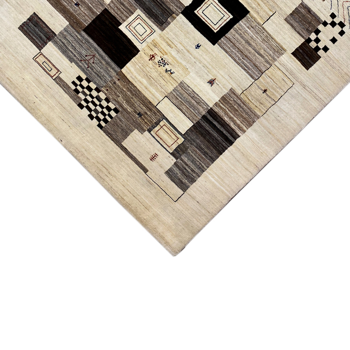 Carpet detail: beige background with dark rectangles, squares, and lines in a patchwork pattern