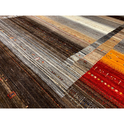 Carpet detail with dense pile, stripes in gray, cream, brown, orange, and red