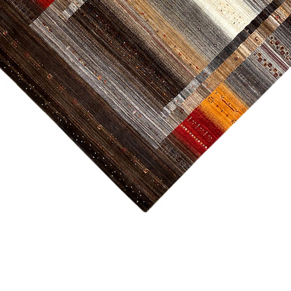 Rug detail at the edge: dark brown with fine lines in gray, cream, orange and red