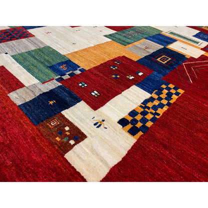 Gabbeh Luri rug close-up: dense patchwork of red, blue, green, and beige