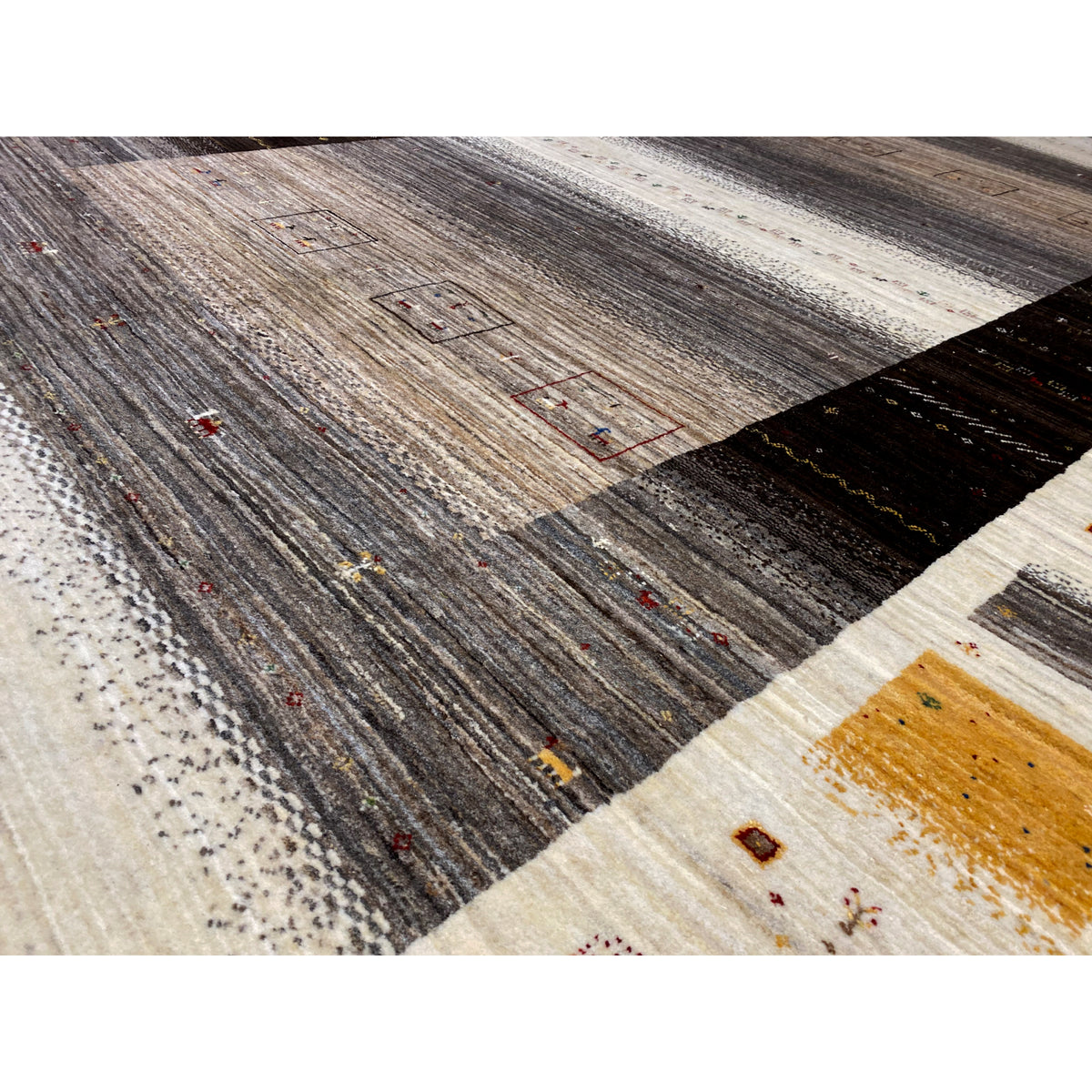 Gabbeh-Luri rug close-up: textured pile, graphic fields in gray and beige