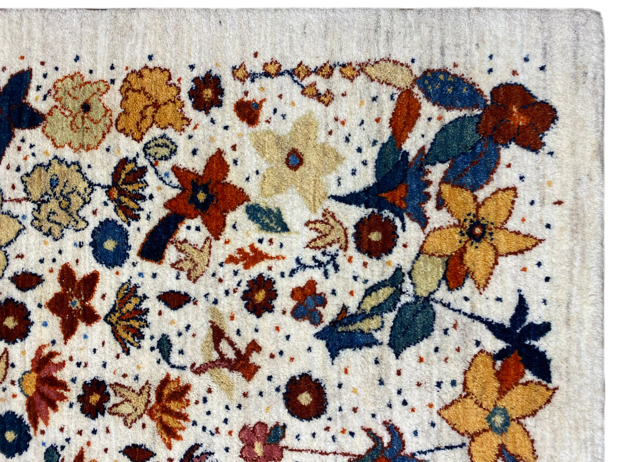 Close-up of a carpet surface with multicolored flowers and a fine woven texture on a light background