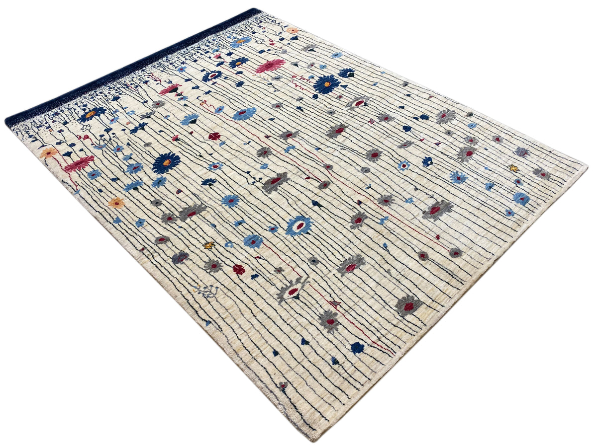 Cremefarbener Luri-Teppich mit blauem Rand und mehrfarbigen Punkt- und Blütendetails