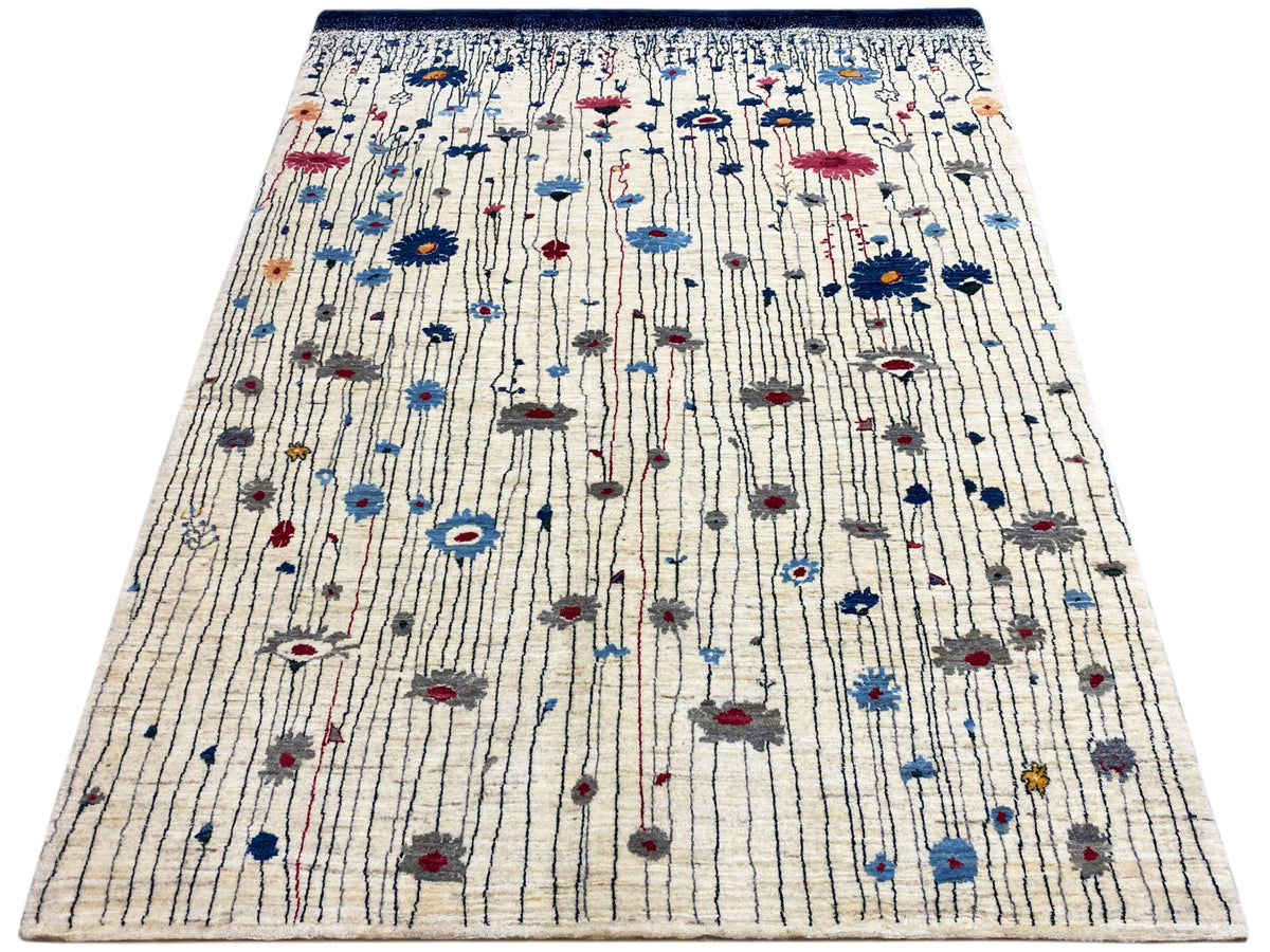 Teppich mit cremefarbener Fläche und blauem Randeinfassungsstreifen mit roten und blauen Mustern