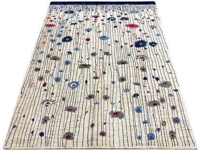 Teppich mit cremefarbener Fläche und blauem Randeinfassungsstreifen mit roten und blauen Mustern
