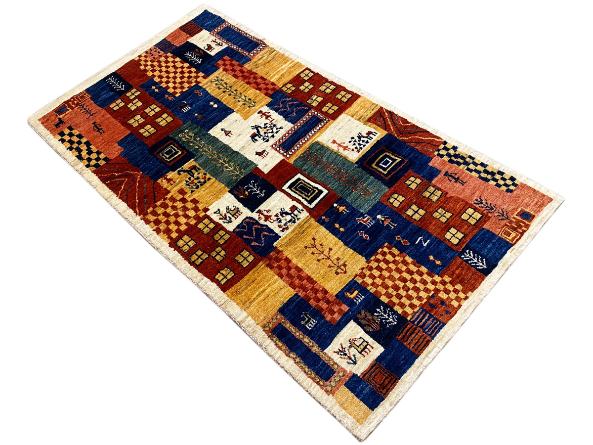 Gabbeh-Luri rug 158x86 cm, laid at an angle: geometric motifs in blue, red, and yellow ochre