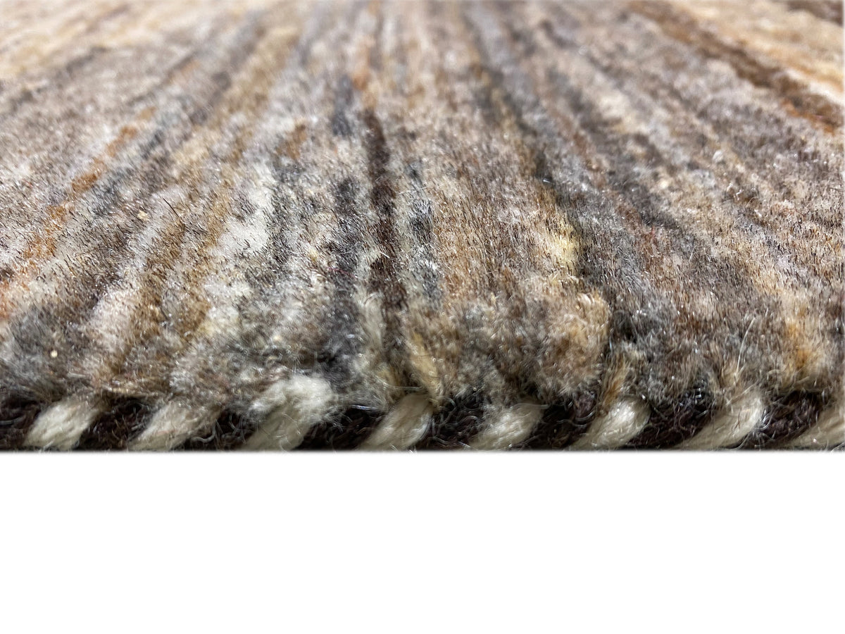Carpet pile in detail: dense, multicolored fibers in gray, beige, and dark brown