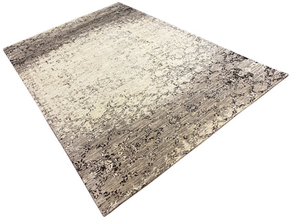 Diagonally oriented rug in beige and dark gray with an abstract pattern