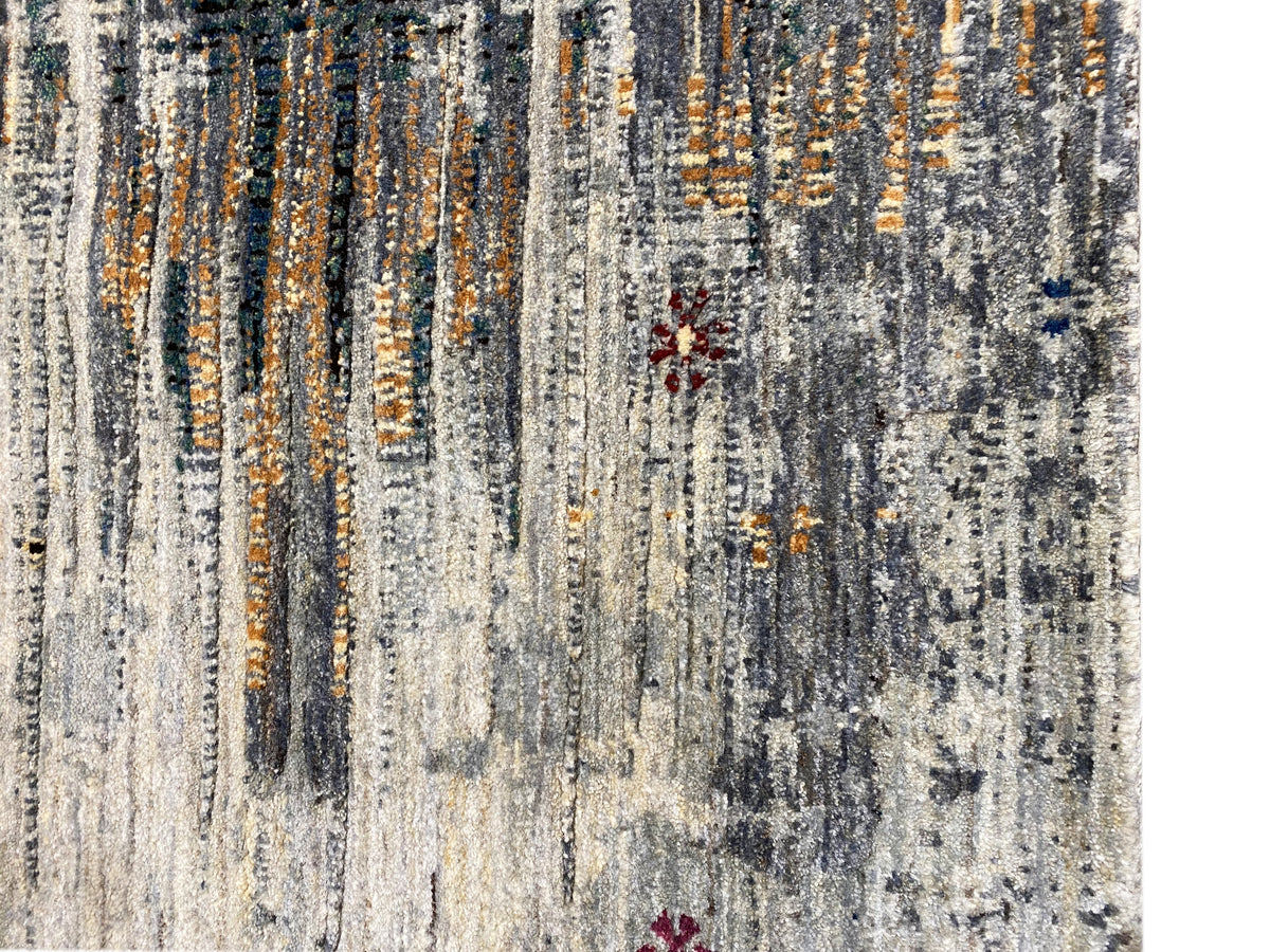 Gabbeh-Luri rug close-up: light gray flatweave with orange lines and spots